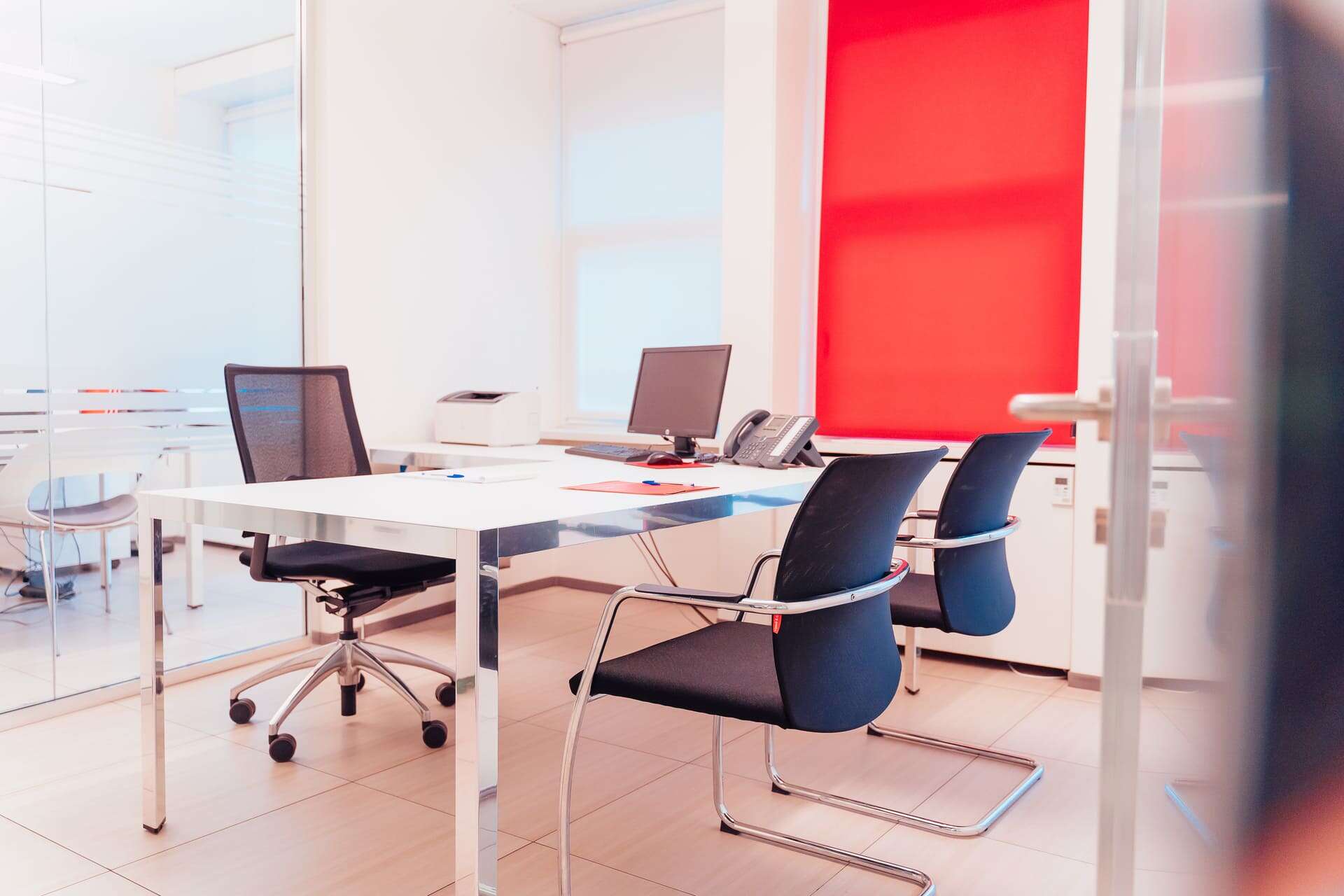 Ufficio con scrivanie, sedie ergonomiche e tecnologia moderna.